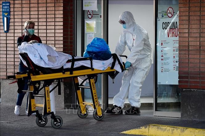 Nhân viên y tế chuyển bệnh nhân nhiễm COVID-19 vào bệnh viện Severo Ochoa ở Leganes, Tây Ban Nha ngày 26/3. Ảnh: AFP/TTXVN