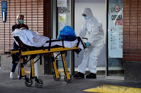 Nhân viên y tế chuyển bệnh nhân nhiễm COVID-19 vào bệnh viện Severo Ochoa ở Leganes, Tây Ban Nha ngày 26/3/2020. Ảnh: AFP/TTXVN