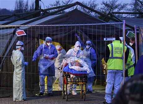 Lực lượng y tế khẩn cấp chuyển bệnh nhân nhiễm COVID-19 từ bệnh viện ở Mulhouse lên xe cứu thương để sơ tán tới các bệnh viện ở phía Tây nước Pháp ngày 29/3/2020. Ảnh: AFP/TTXVN