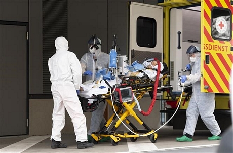 Nhân viên y tế chuyển bệnh nhân nhiễm COVID-19 từ xe cứu thương vào một bệnh viện ở Dresden, Đức ngày 26/3/2020. Ảnh: AFP/TTXVN
