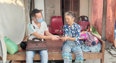 Anh Nguyễn Thanh Tâm trao tiền hỗ trợ cho cô Nguyễn Thị Bảy- người lấy vé số ở đại lý của anh Tâm bán dạo gần 20 năm.
