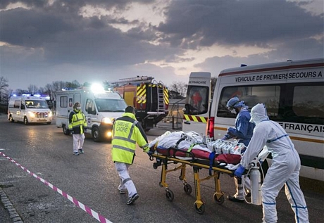 Nhân viên y tế chuyển bệnh nhân nhiễm COVID-19 lên xe cứu thương tại Mulhouse, Pháp, ngày 29/3/2020. Ảnh: AFP/TTXVN