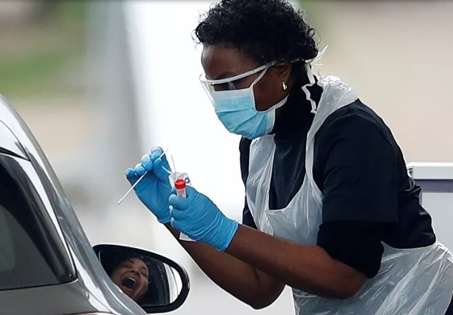 Nhân viên y tế của Dịch vụ Y tế Quốc gia Anh NHS lấy mẫu phẩm tại trạm xét nghiệm nhanh ở Chessington, Ảnh. Ảnh: Reuters
