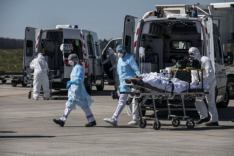 Nhân viên y tế chuyển bệnh nhân mắc COVID-19 tại sân bay Bale-Mulhouse, Pháp, ngày 31/3/2020. Ảnh: AFP/ TTXVN