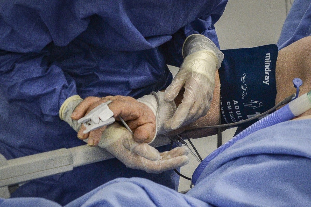 Nhân viên y tế nắm tay bệnh nhân tại phòng chăm sóc tích cực ở bệnh viện Brescia, Italy. Ảnh: EPA-EFE