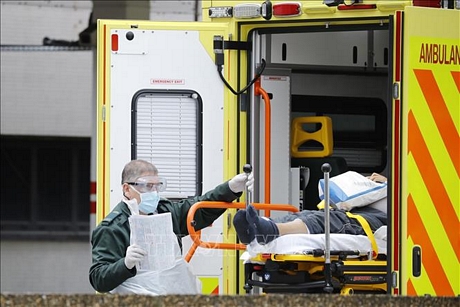 Nhân viên y tế chuyển bệnh nhân nhiễm COVID-19 tới bệnh viện ở London, Anh, ngày 31/3/2020. Ảnh: AFP/TTXVN