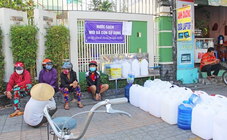 Người dân chờ lấy nước ngọt ở một điểm tư nhân chia sẻ trên Đại lộ Đồng Khởi (TP Bến Tre) ngày 21/3/2020.