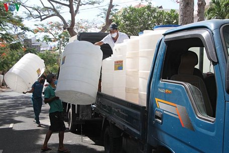 Những bồn chứa nước và gạo chuẩn bị chuyển đi hỗ trợ người dân.