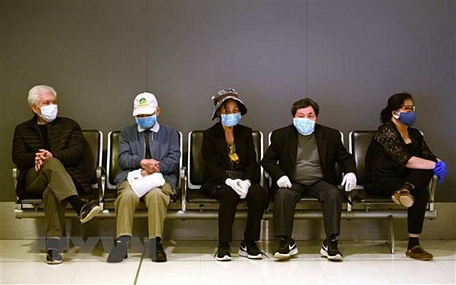Hành khách đeo khẩu trang phòng dịch COVID-19 tại sân bay quốc tế Sydney, Australiaa. (Ảnh: AFP/TTXVN)
