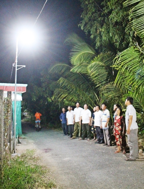 Lãnh đạo xã và người dân phấn khởi khi mô hình “Đèn đường thắp sáng miền quê” được thắp sáng lần đầu tiên vào đêm 13/5/2020. 
