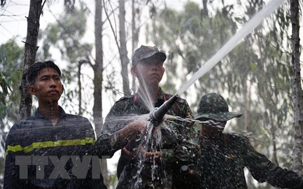 Cán bộ chiến sỹ Bộ Chỉ huy Quân sự tỉnh Kiên Giang chữa cháy rừng tràm. (Ảnh: Lê Phương Vũ/TTXVN)