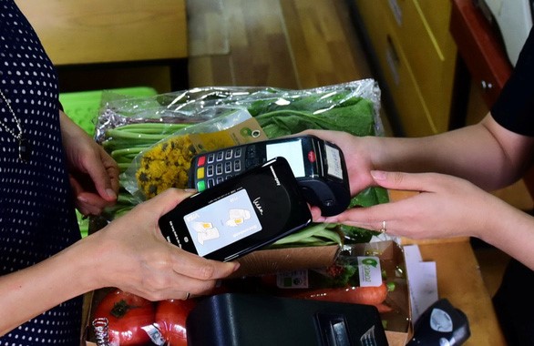 Người tiêu dùng ngày càng mang theo tiền mặt ít hơn, thay vào đó là các phương thức thanh toán mới như cà thẻ, thanh toán trên các thiết bị di động - Ảnh: QUANG ĐỊNH    