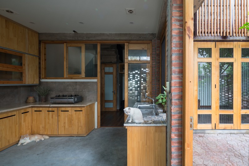 Tủ bếp bằng gỗ ấm cúng đặt trong nhà bếp làm bằng bê tông và gạch thô.