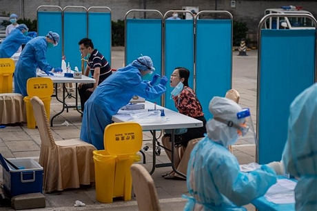 Nhân viên y tế lấy mẫu xét nghiệm COVID-19 cho người dân tại Bắc Kinh, Trung Quốc ngày 28/5/2020. Ảnh: AFP/TTXVN