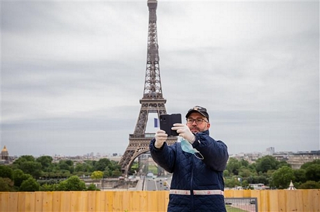 Người dân tại khu vực Tháp Eiffel ở thủ đô Paris, Pháp ngày 18/3/2020. Ảnh: AFP/TTXVN
