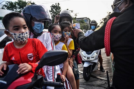 Kiểm tra thân nhiệt cho người dân tại Bangkok, Thái Lan. Ảnh: AFP/ TTXVN