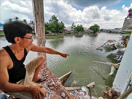 Ông Phan Anh, chủ căn nhà số 118 đường Lê Thị Hồng Gấm, phường Trà An, quận Bình Thủy chỉ về phía phần nhà của sông đã bị sạt hoàn toàn xuống sông. 