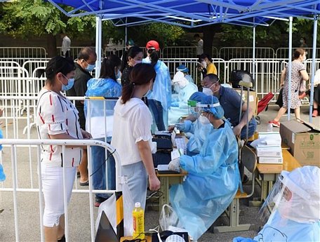 Nhân viên y tế lấy mẫu dịch xét nghiệm COVID-19 cho người dân tại Bắc Kinh, Trung Quốc, ngày 26/6/2020. (Nguồn: THX/TTXVN)