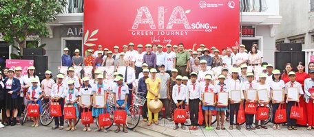 AIA Việt Nam và lãnh đạo địa phương trao tặng xe đạp cho học sinh và gạo cho hộ nghèo.