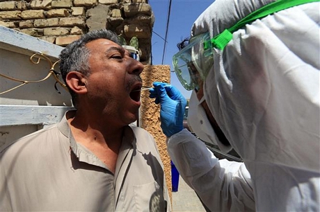 Nhân viên y tế lẫy mẫu xét nghiệm COVID-19 tại Baghdad, Iraq. Ảnh: THX/TTXVN