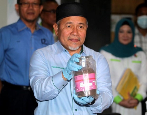 Bộ trưởng Nước và Môi trường Malaysia Tuan Ibrahim Tuan Man cầm trên tay mẫu bụi lò thép độc hại trong các container tại Cảng Tanjung Pelepas ngày 19/7. (Nguồn: thestar.com.my)