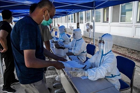 Người dân đăng ký xét nghiệm COVID-19 tại Bắc Kinh, Trung Quốc ngày 17/6/2020. Ảnh: AFP/TTXVN
