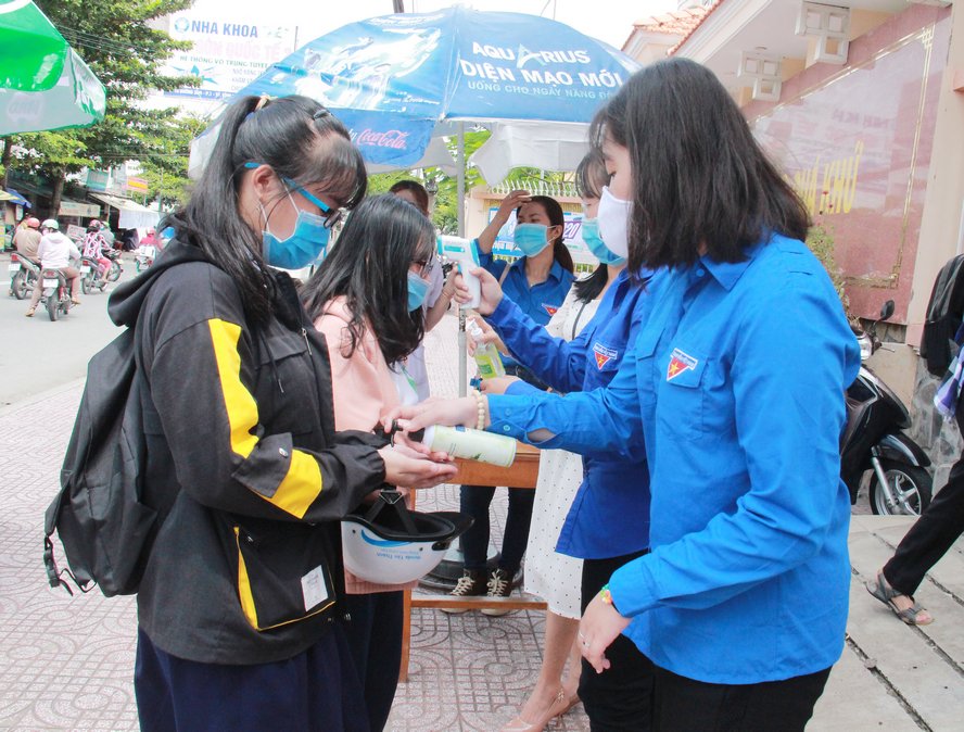 Thanh niên tình nguyện hỗ trợ rửa tay sát khuẩn cho các thí sinh.