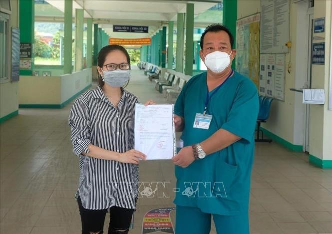 Đại diện Bệnh viện Phổi Đà Nẵng trao giấy chứng nhận khỏi bệnh COVID-19 và xuất viện cho bệnh nhân 615. Ảnh: Văn Dũng/TTXVN