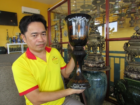 Anh Phạm Văn Hai với chiếc cúp gỗ sản xuất năm 1995.