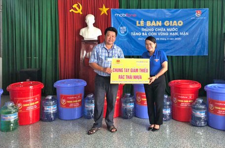 Chị Nguyễn Thị Đoàn trao thùng chứa nước cho bà con vùng hạn, mặn.