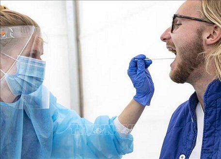 Nhân viên y tế lấy mẫu dịch xét nghiệm COVID-19 cho người dân tại Lund, Thụy Điển. Ảnh: AFP/TTXVN