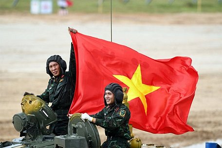 Kíp số 1 của đội xe tăng Việt Nam cầm cờ ăn mừng sau khi về đích tại trận ra quân hôm 24/8. (Ảnh: QĐND)