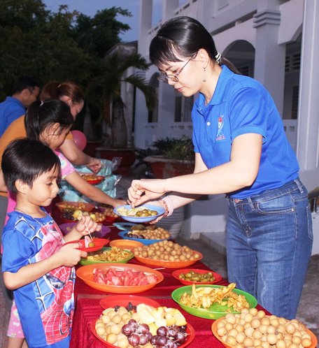 Chị Nguyễn Thị Diệu Huyền hỗ trợ mạnh thường quân tổ chức sân chơi, phát quà, bánh, trái cây cho thiếu nhi.