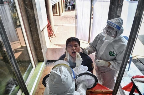 Nhân viên y tế lấy mẫu dịch xét nghiệm COVID-19 cho người dân tại Bangkok, Thái Lan, ngày 6/5/2020. Ảnh: AFP/ TTXVN