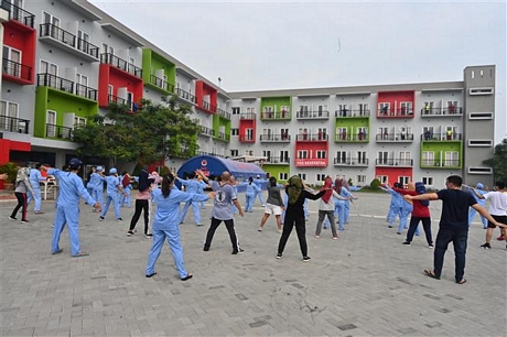 Nhân viên y tế hướng dẫn các bệnh nhân COVID-19 tập thể dục buổi sáng tại trung tâm cách ly ở Tangerang, Indonesia, ngày 15/7/2020. Ảnh: AFP/ TTXVN