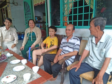 Bác sĩ Nguyễn Ngọc Thơ (ngoài cùng bên trái) đến thăm gia đình cháu Nhã Thơ- bệnh nhi nhũn não đã được điều trị lành bệnh (ngồi giữa).