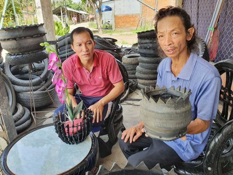 Anh Nguyễn Văn Hoàng và anh Lê Văn Dội giới thiệu bộ bàn ghế và giỏ hoa làm từ vỏ xe phế liệu.