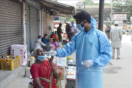 Nhân viên y tế lấy mẫu xét nghiệm COVID-19 cho người dân tại Hyderabad, Ấn Độ ngày 30/8. Ảnh: THX/TTXVN