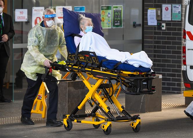 Nhân viên y tế chuyển bệnh nhân mắc COVID-19 lên xe cứu thương tại Melbourne, bang Victoria, Australia ngày 20/7/2020. Ảnh: AFP/TTXVN