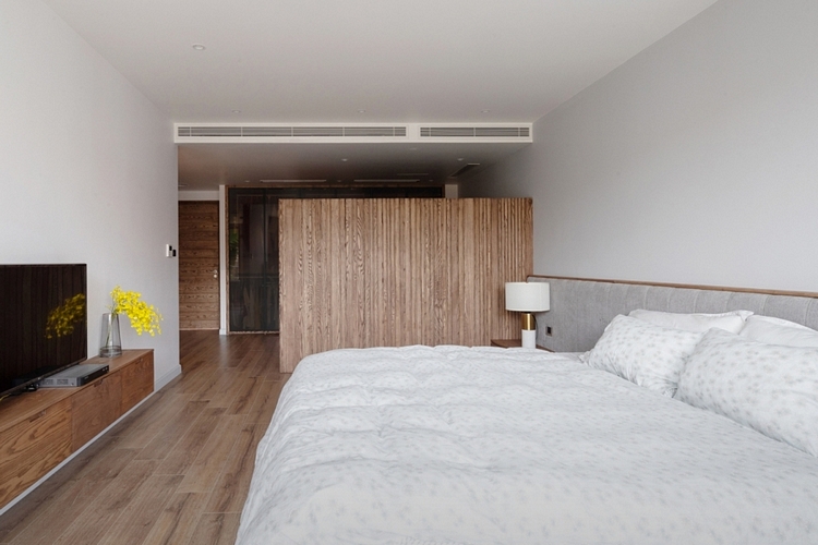 Sàn phòng ngủ ốp gỗ tương phản với trần thạch cao bên trên.