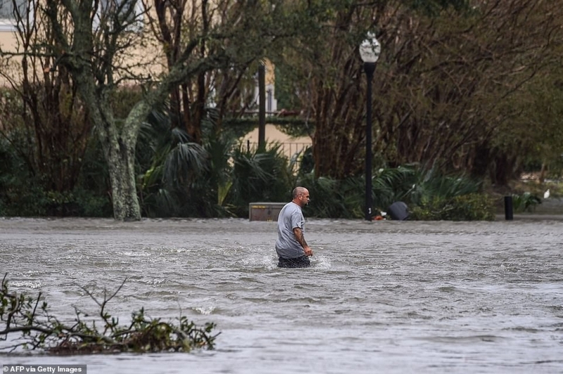 Một người đàn ông phải lội qua con đường bị nước ngập sâu ở Pensacola, Florida. Ảnh: AFP.