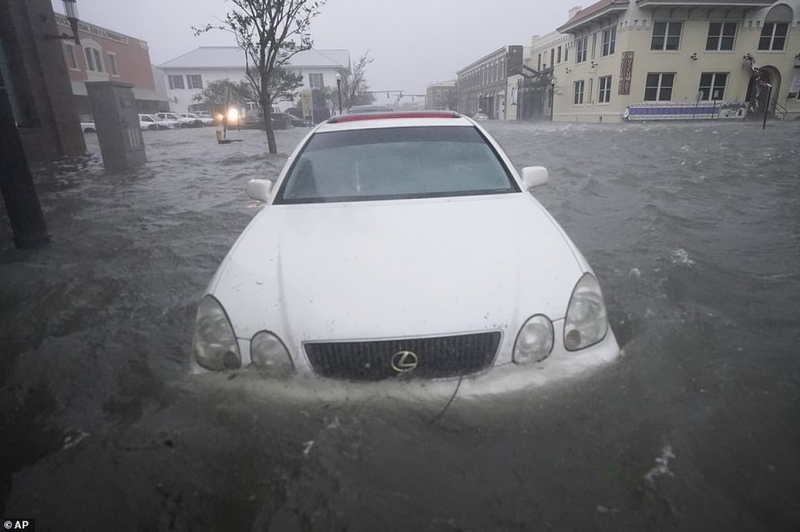 Một chiếc ô tô bị mắc kẹt giữa biển nước mênh mông tại Pensacola. Ảnh: AP.