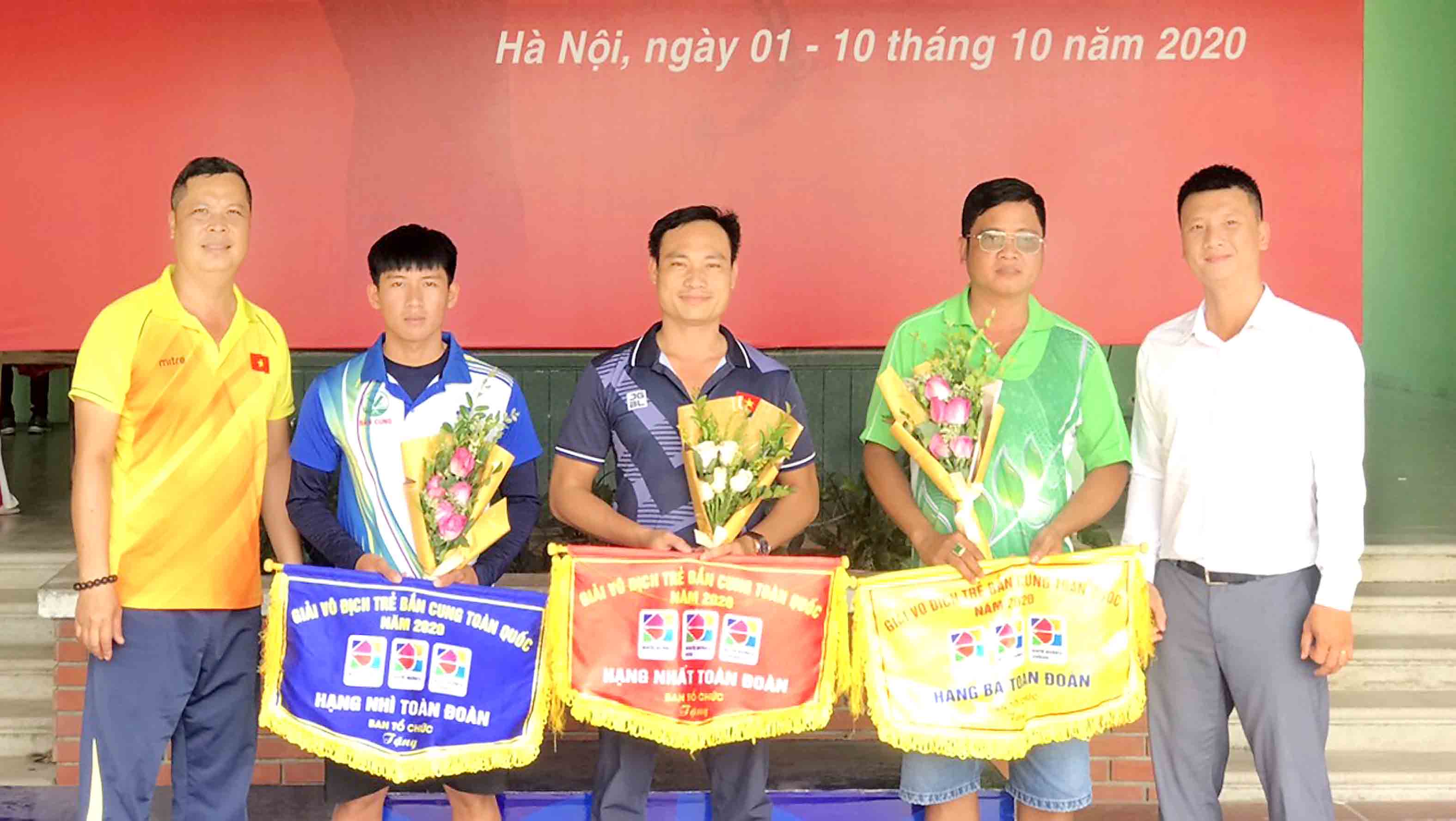 Ông Cáp Mạnh Tân- HLV trưởng ĐT Bắn cung Việt Nam (bìa trái) trao cờ thưởng toàn đoàn cho các đơn vị.