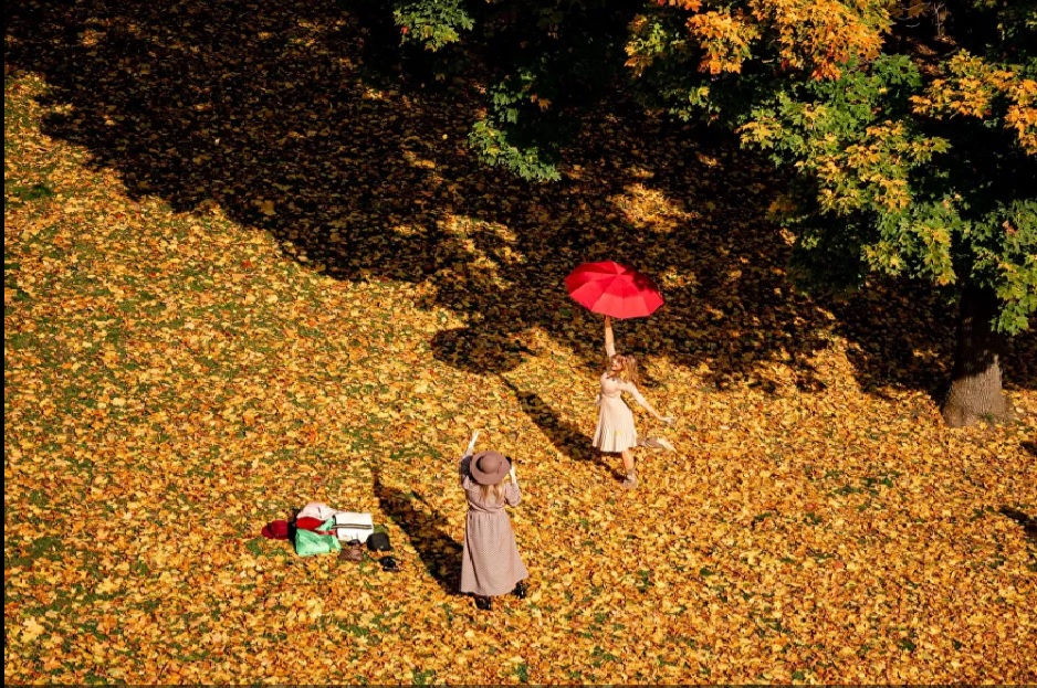 Một phụ nữ tạo dáng với ô trong một ngày thu đầy nắng ở công viên Tsaritsyno Park, ở thủ đô Moskva