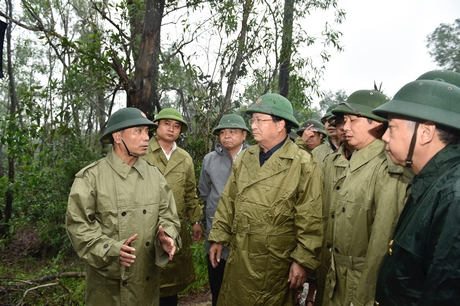 Tư lệnh Quân khu 4 Nguyễn Doãn Anh (bìa trái) báo cáo tình hình với Phó thủ tướng Trịnh Đình Dũng (giữa) tại huyện Phong Điền, Thừa Thiên Huế, chiều 13/10. Ảnh: VGP/Nhật Bắc