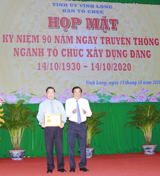 Phó Bí thư Thường trực Tỉnh ủy- Bùi Văn Nghiêm trao Kỷ niệm chương Vì sự nghiệp tổ chức xây dựng Đảng cho Bí thư Tỉnh ủy- Trần Văn Rón.