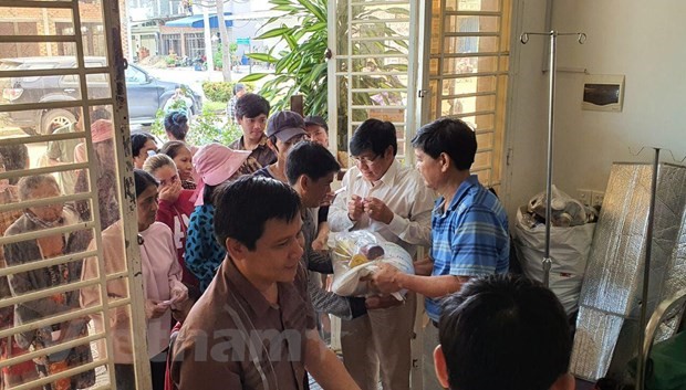 Tổng Lãnh sự Vũ Ngọc Lý (áo xanh) cùng đoàn công tác trao đồ cứu trợ cho bà con gốc Việt tại Kampong Speu. (Ảnh: Trần Long/Vietnam+)