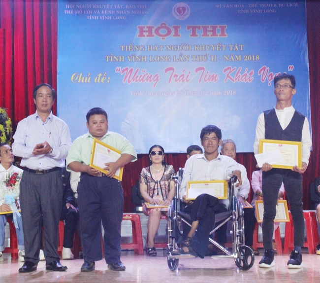 Anh Nguyễn Hoàng Thơ (thứ 2 từ trái sang) nhận giải thưởng trong cuộc thi hát dành cho người khuyết tật.