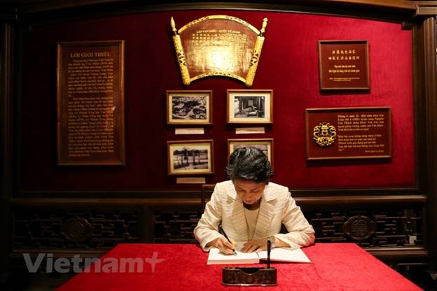 Bà Suga Mariko ký sổ lưu niệm tại Văn Miếu Quốc Tử Giám. Ảnh: Minh Sơn/Vietnam+