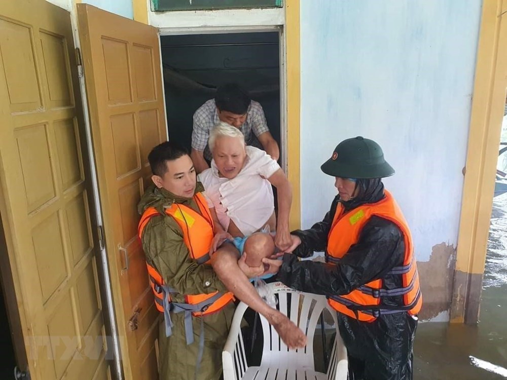  Người già, trẻ em vùng ngập lụt ở Hà Tĩnh được đưa đến những địa điểm an toàn. (Ảnh: TTXVN)